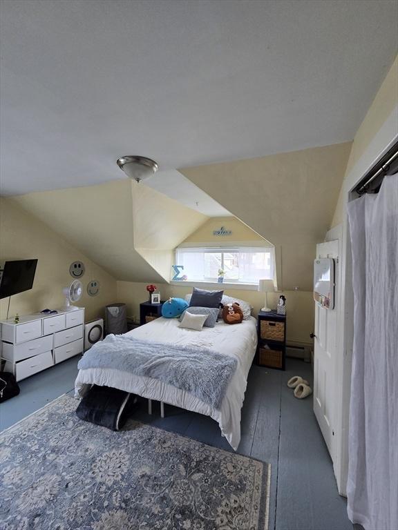 bedroom with vaulted ceiling and a baseboard radiator