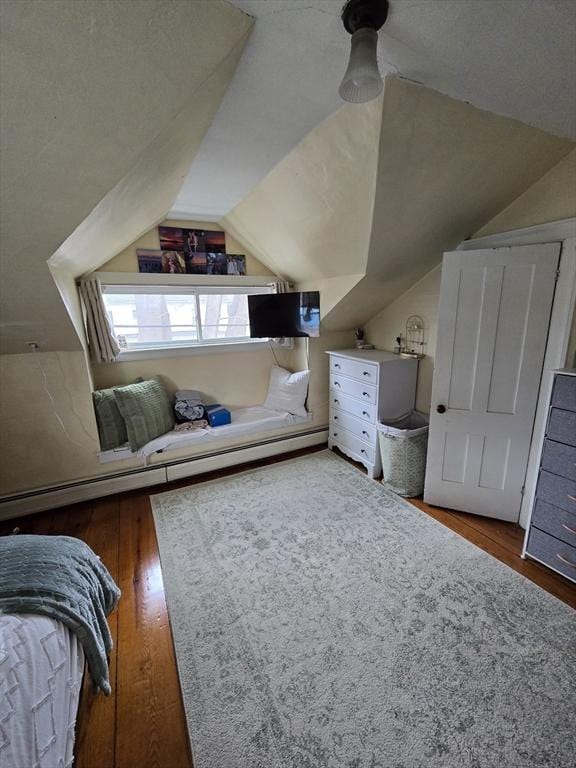 bedroom with vaulted ceiling and wood finished floors