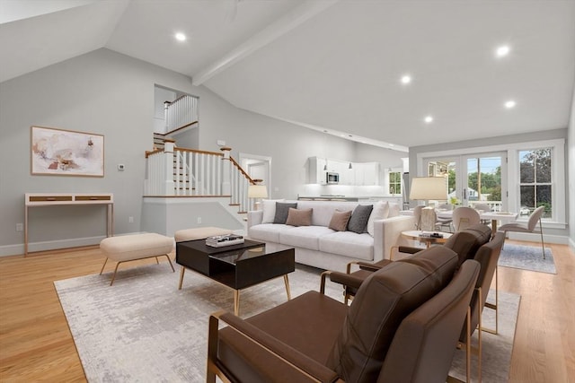 living room with vaulted ceiling with beams and light wood-type flooring