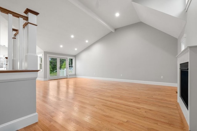 unfurnished living room with lofted ceiling with beams and light hardwood / wood-style floors