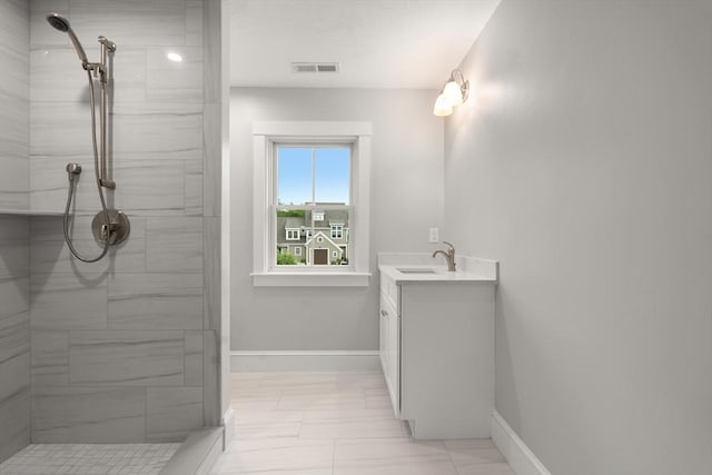 bathroom with vanity and tiled shower