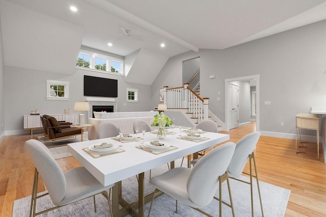 dining space featuring vaulted ceiling with beams and light wood-type flooring