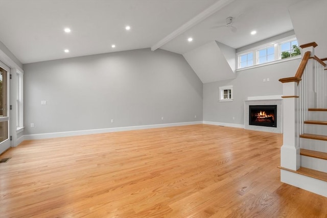 unfurnished living room featuring ceiling fan, light hardwood / wood-style flooring, and lofted ceiling with beams