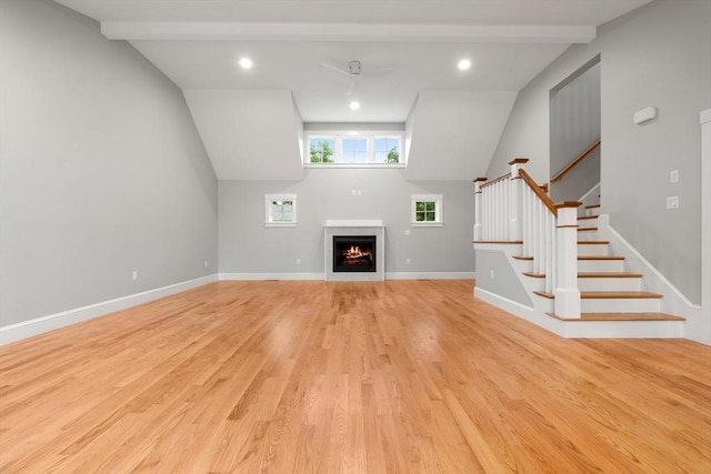 unfurnished living room with vaulted ceiling with beams and light hardwood / wood-style flooring