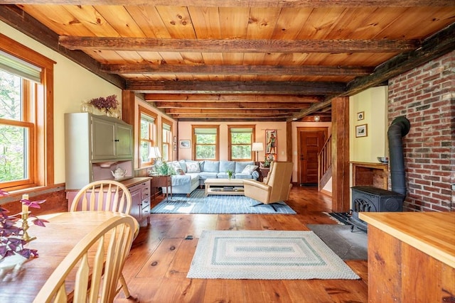 78 Wickett Pond Rd, Wendell, MA 01379 - dining space featuring hardwood / wood-style flooring, a wood ceiling with exposed beams, a wood stove, stairway, and wainscoting
