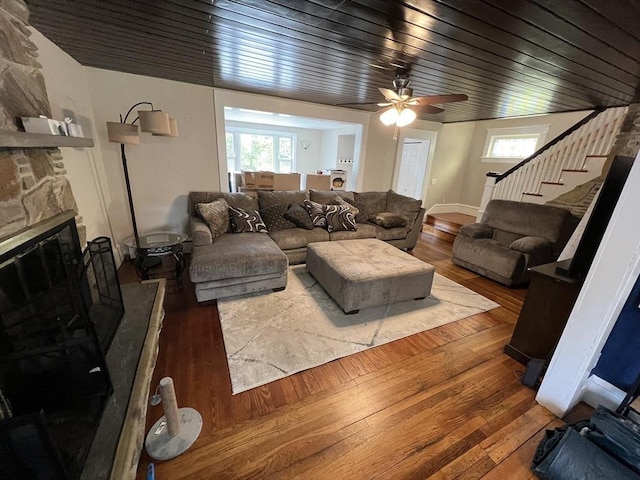 living area featuring healthy amount of natural light, a fireplace, wood-type flooring, and stairs