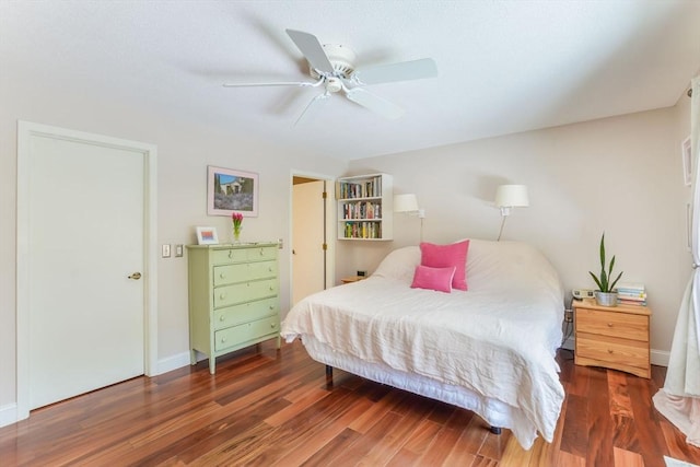bedroom featuring a ceiling fan, baseboards, and wood finished floors