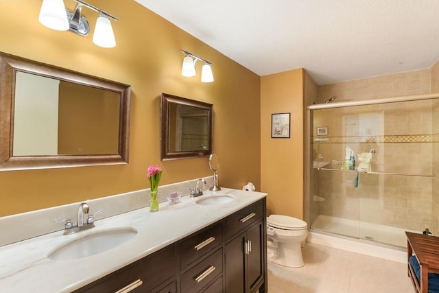 full bathroom featuring double vanity, toilet, a sink, and a stall shower