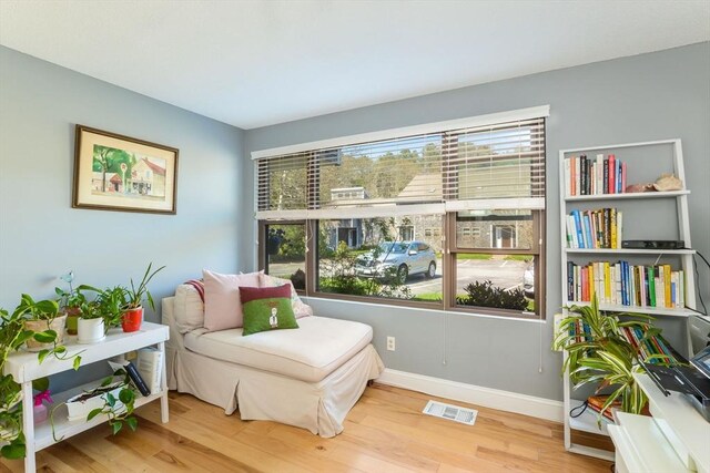 sitting room with visible vents, wood finished floors, and a wealth of natural light