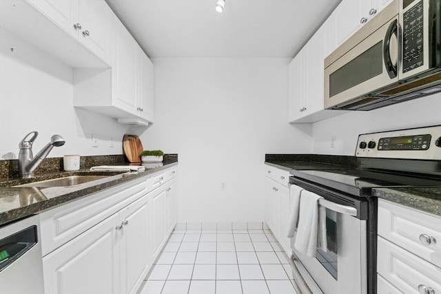 300 Allston Unit 205, Boston, MA 02135 - kitchen featuring stainless steel appliances, white cabinets, dark stone counters, and light tile patterned floors