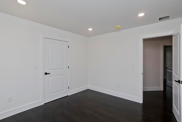 unfurnished room with dark hardwood / wood-style flooring