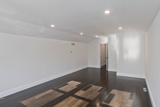 empty room with lofted ceiling and dark wood-type flooring