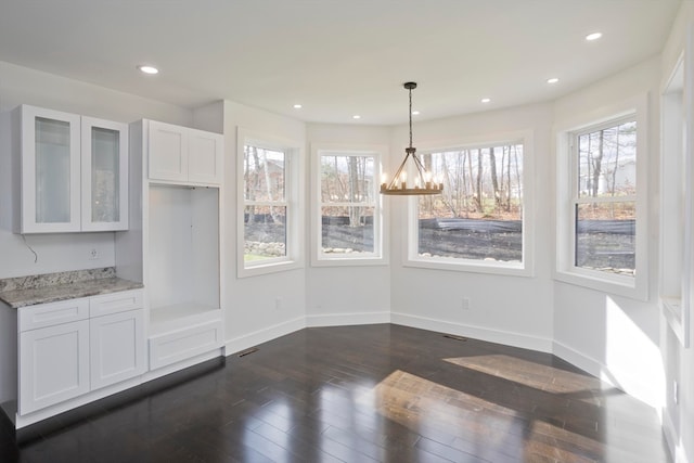 unfurnished dining area with dark wood-type flooring