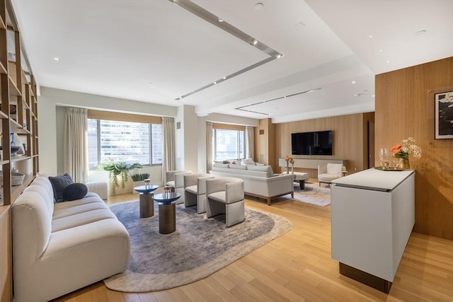 living room featuring light wood-style floors and wood walls