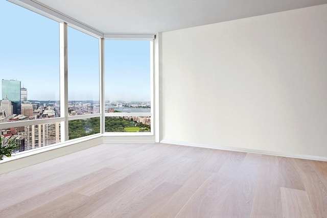 unfurnished room featuring a water view and light hardwood / wood-style flooring