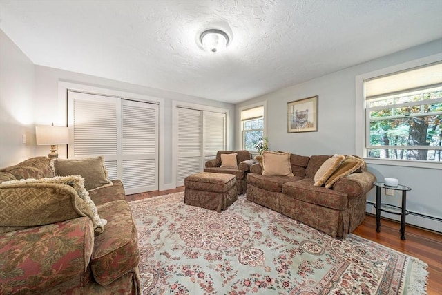 living room featuring a textured ceiling, hardwood / wood-style flooring, and a baseboard radiator