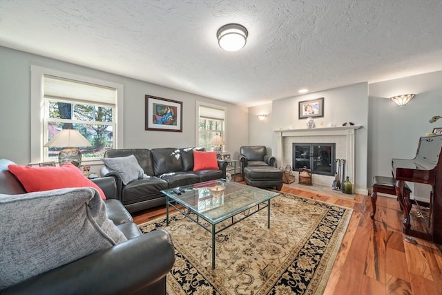 living room featuring a healthy amount of sunlight, a textured ceiling, and wood-type flooring