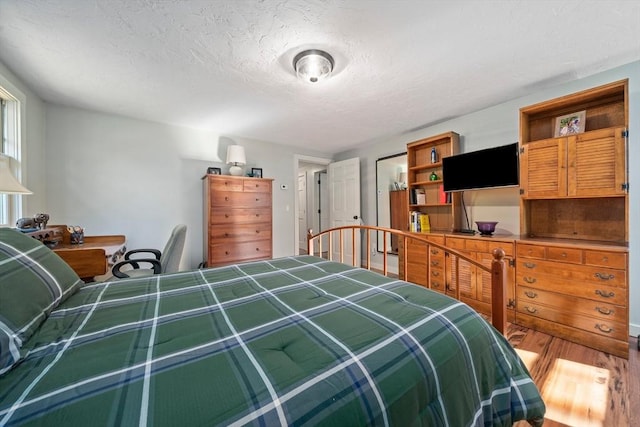 bedroom featuring a textured ceiling and hardwood / wood-style flooring