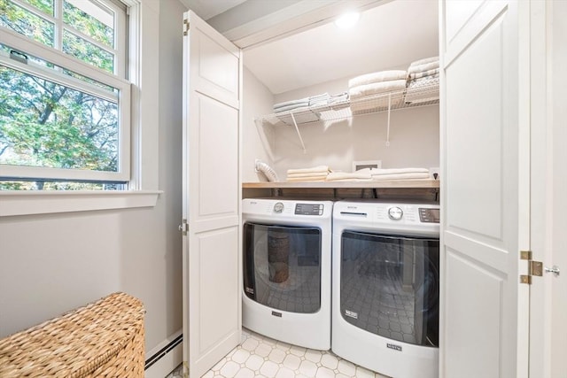 clothes washing area featuring washer and dryer and a baseboard heating unit