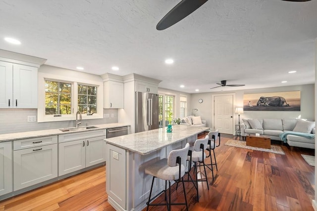 kitchen with a healthy amount of sunlight, ceiling fan, sink, and stainless steel appliances