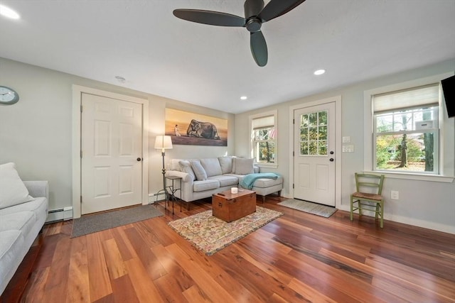 living room with hardwood / wood-style flooring, ceiling fan, a healthy amount of sunlight, and a baseboard heating unit