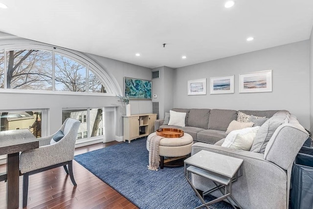 living area with recessed lighting, visible vents, and wood finished floors