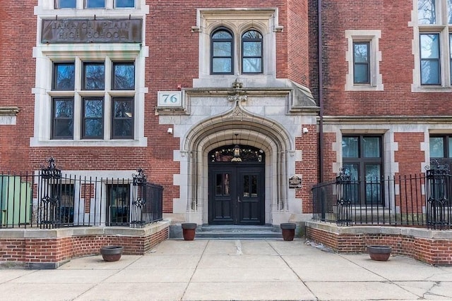 doorway to property featuring brick siding