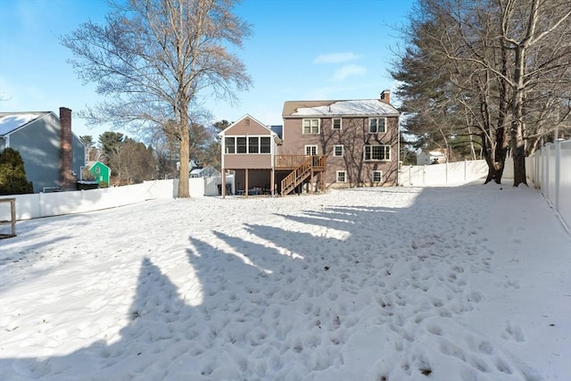 snow covered property featuring a sunroom