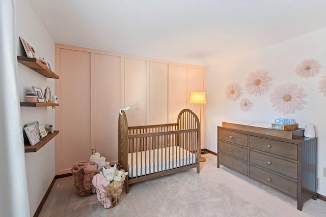 bedroom with a crib and light colored carpet