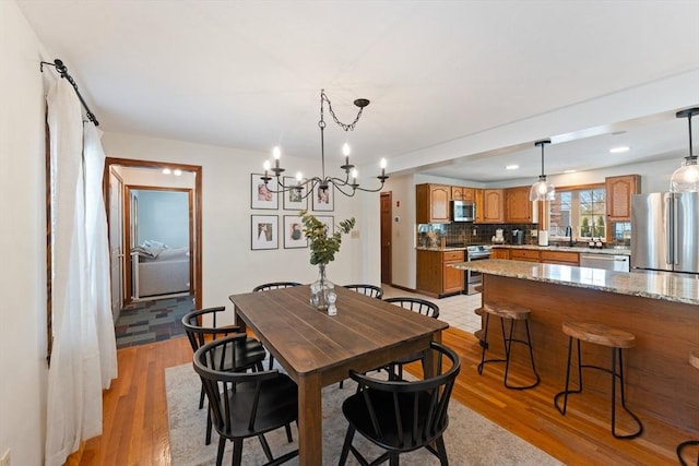 dining area with sink and light wood-type flooring