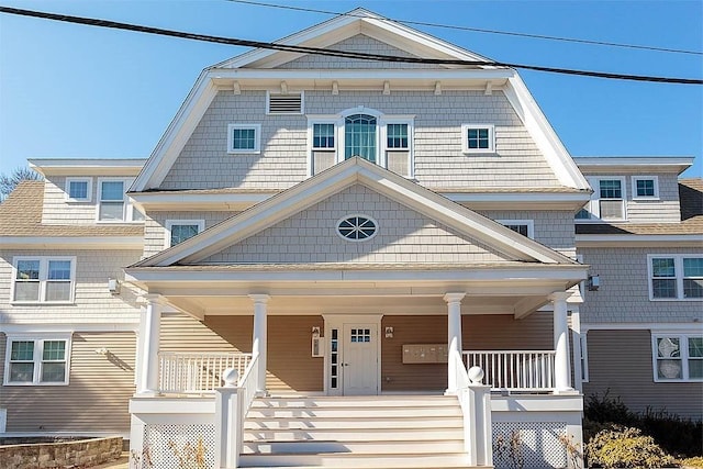 shingle-style home with a porch and a gambrel roof