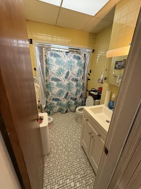 50 Proctor Ave, Revere, MA 02151 - full bath featuring vanity, toilet, a shower with shower curtain, and a paneled ceiling