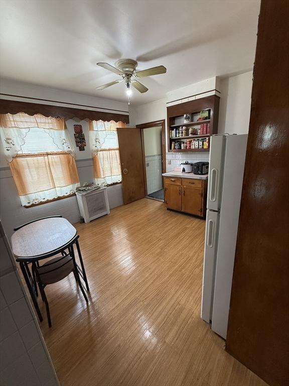 50 Proctor Ave, Revere, MA 02151 - kitchen with freestanding refrigerator, ceiling fan, light wood-type flooring, open shelves, and light countertops