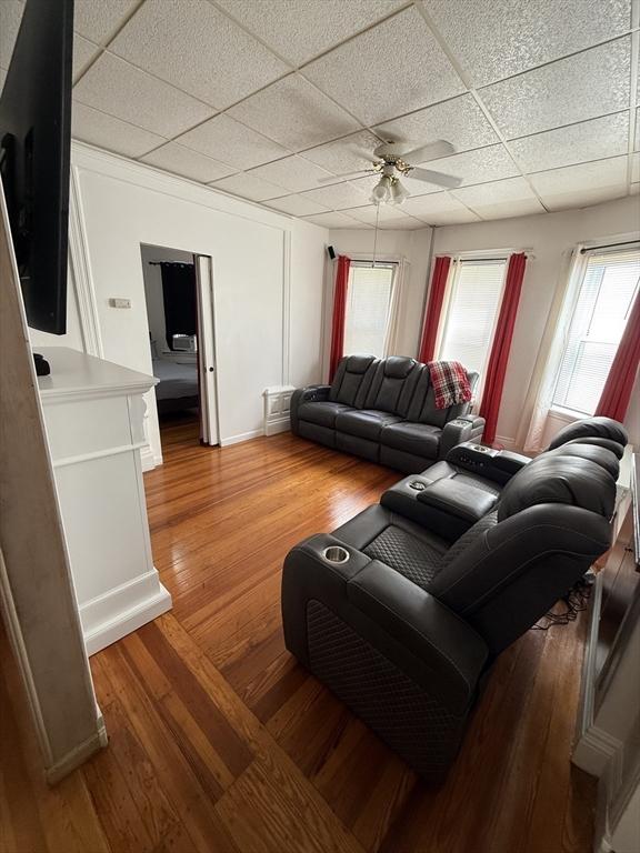 50 Proctor Ave, Revere, MA 02151 - living room featuring a drop ceiling, ceiling fan, light wood-type flooring, and baseboards