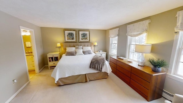 carpeted bedroom featuring a baseboard radiator and ensuite bathroom