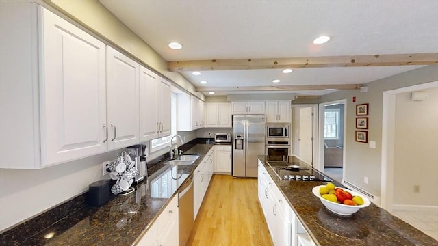 kitchen with stainless steel appliances, white cabinetry, and beam ceiling