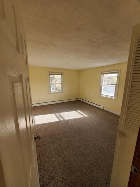 empty room featuring carpet floors and baseboard heating