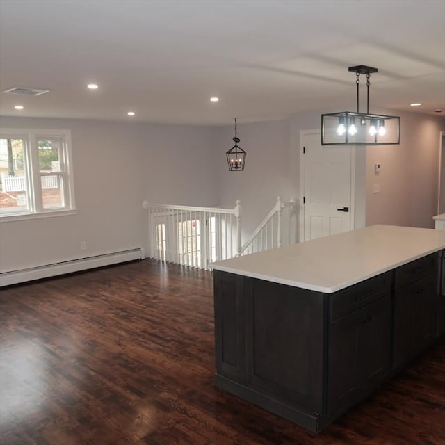 kitchen with a center island, decorative light fixtures, baseboard heating, and dark wood-type flooring