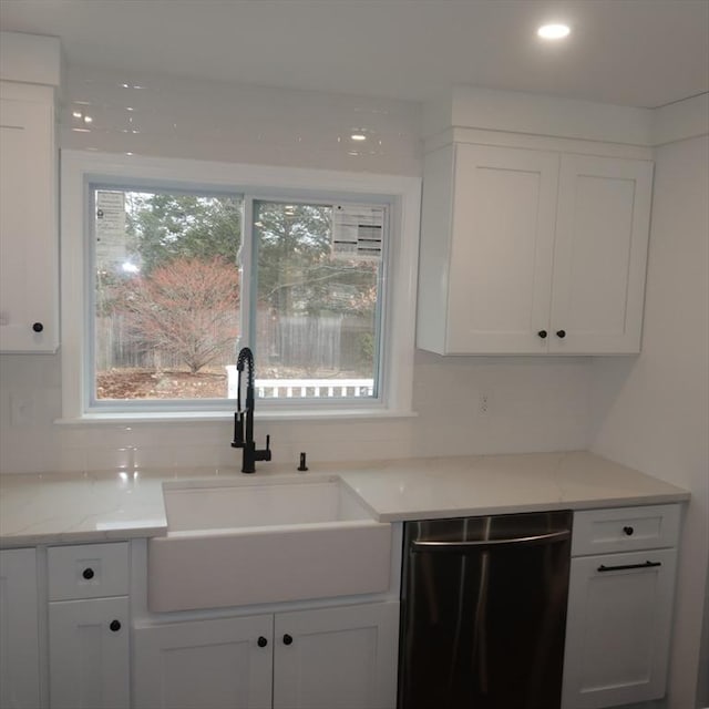 kitchen featuring light stone counters, sink, white cabinets, and stainless steel dishwasher