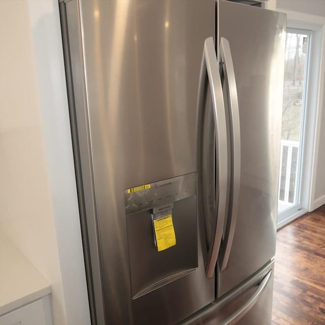 interior details featuring dark hardwood / wood-style floors and stainless steel fridge