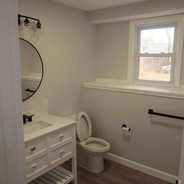 bathroom with wood-type flooring, vanity, and toilet