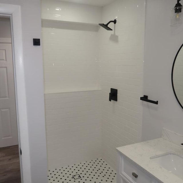 bathroom featuring a tile shower, vanity, and hardwood / wood-style floors