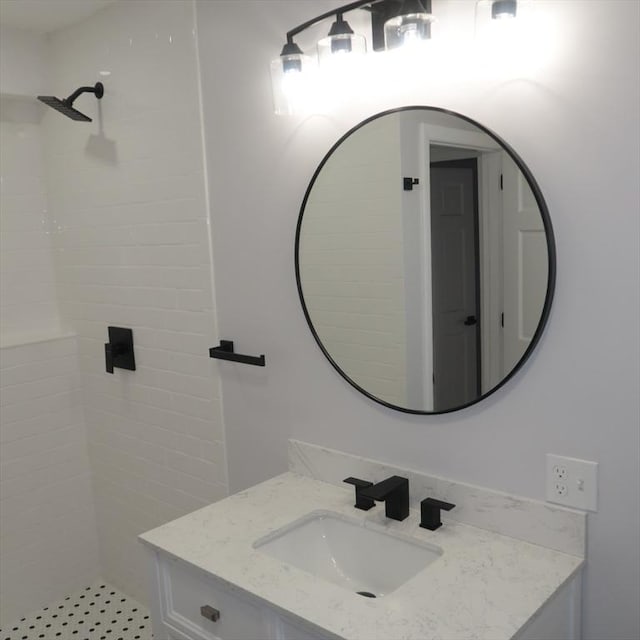 bathroom with vanity and tiled shower