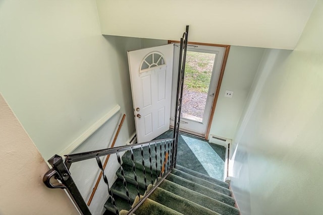 stairway with carpet, baseboards, and baseboard heating
