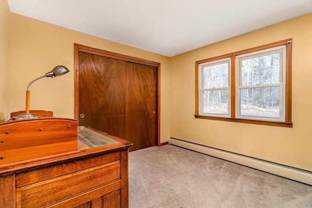 office area featuring a baseboard heating unit, baseboards, and light colored carpet