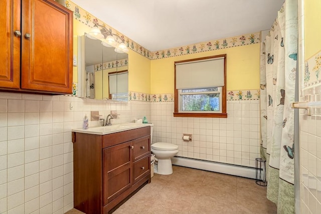 bathroom featuring a baseboard heating unit, wainscoting, vanity, tile walls, and toilet