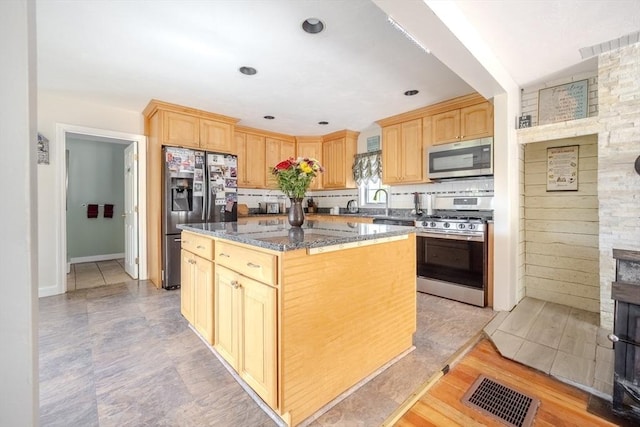 342 Townsend Rd, Groton, MA 01450 - kitchen featuring stainless steel appliances, light brown cabinetry, a kitchen island, dark stone countertops, and tasteful backsplash