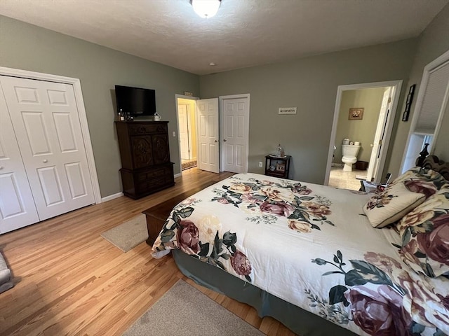 bedroom with wood-type flooring and ensuite bath