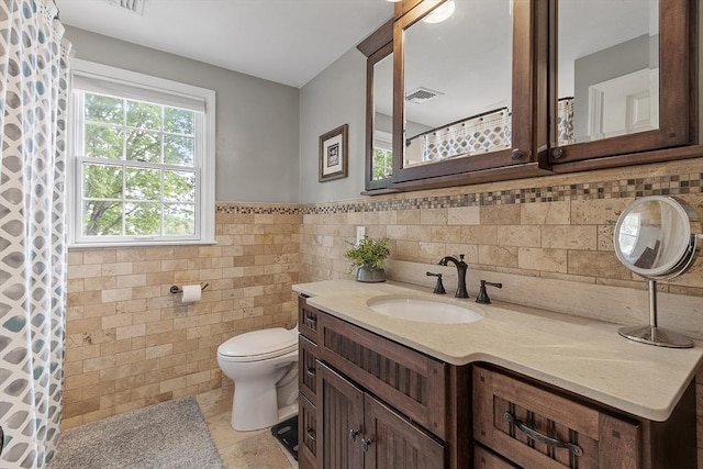 4 Elizabeth Rd, Hudson, MA 01749 - bathroom with toilet, vanity, tile walls, and wainscoting