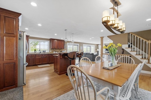 4 Elizabeth Rd, Hudson, MA 01749 - dining space featuring light wood finished floors, recessed lighting, stairway, and ornate columns
